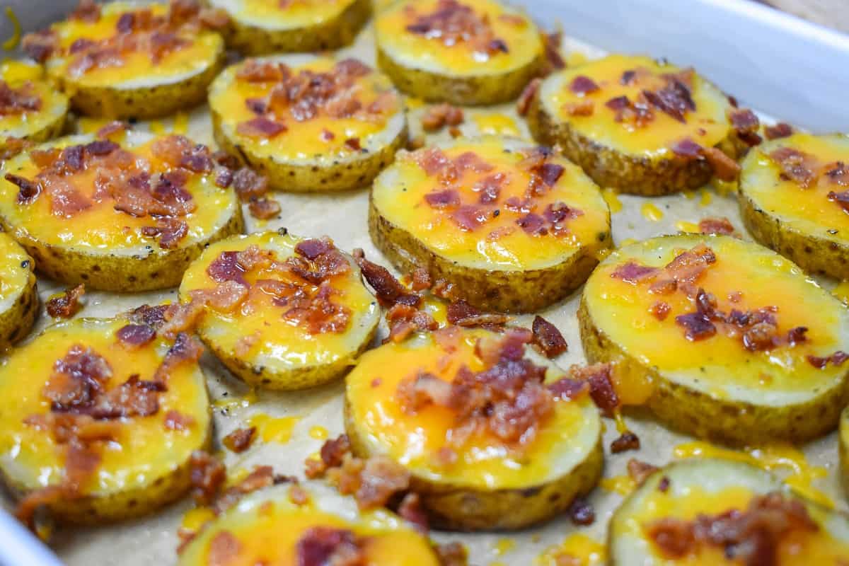 The baked potato slices arranged on a parchment paper lined baking sheet.