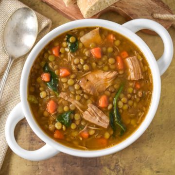 The turkey and lentil soup served in a white bowl.