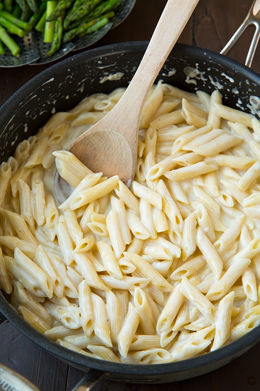 penne tossed with cheesey sauce in skillet