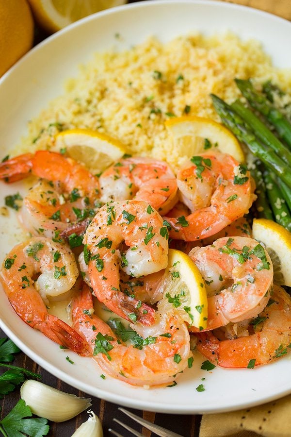 Lemon Garlic Shrimp on a white serving plate with a side of couscous and asparagus.