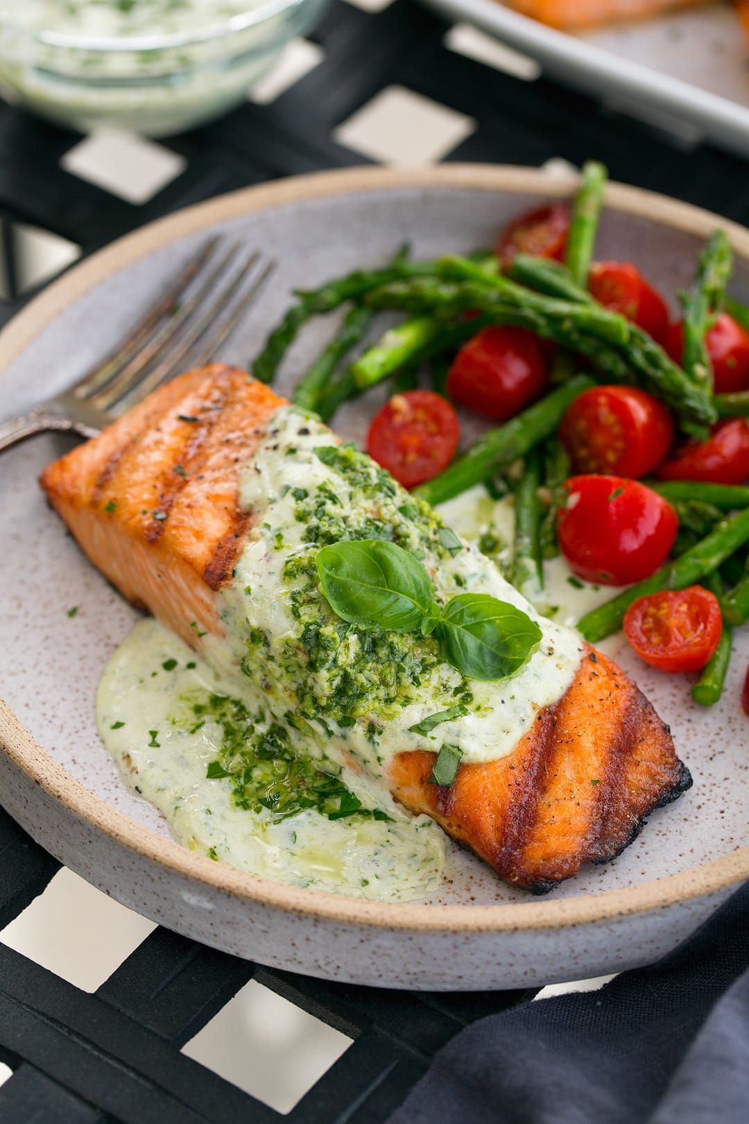 Grilled Salmon fillet with Creamy Pesto sauce on plate with veggies