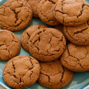 Molasses cookies layered on a blue plate.