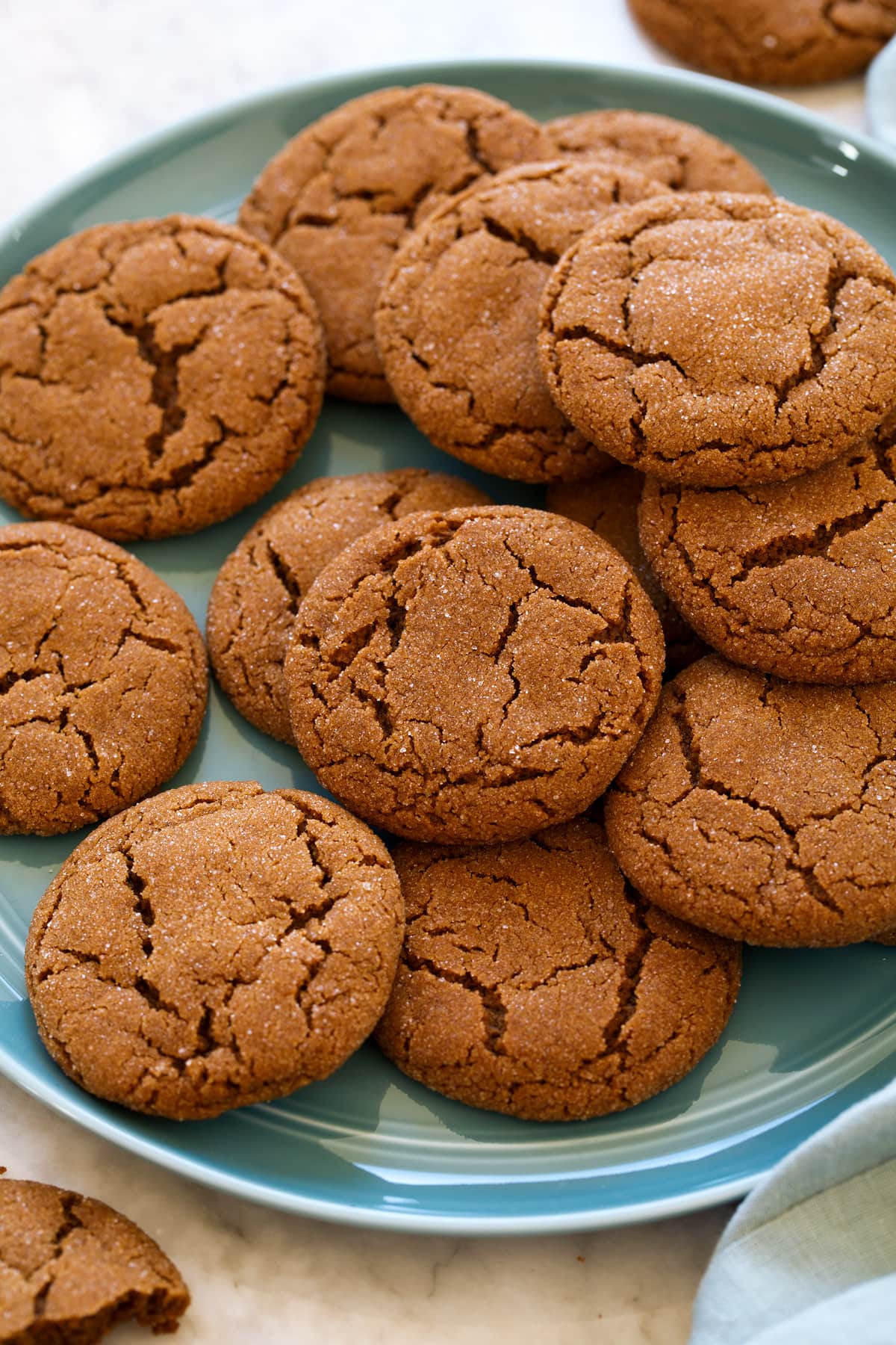 Molasses cookies layered on a blue plate.