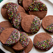 Chocolate Shortbread Cookies coated halfway in chocolate coating and covered with sprinkles.