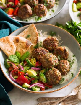 Greek meatballs shown served with tzatziki and greek salad.