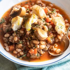 Sausage and bean stew in white bowls.