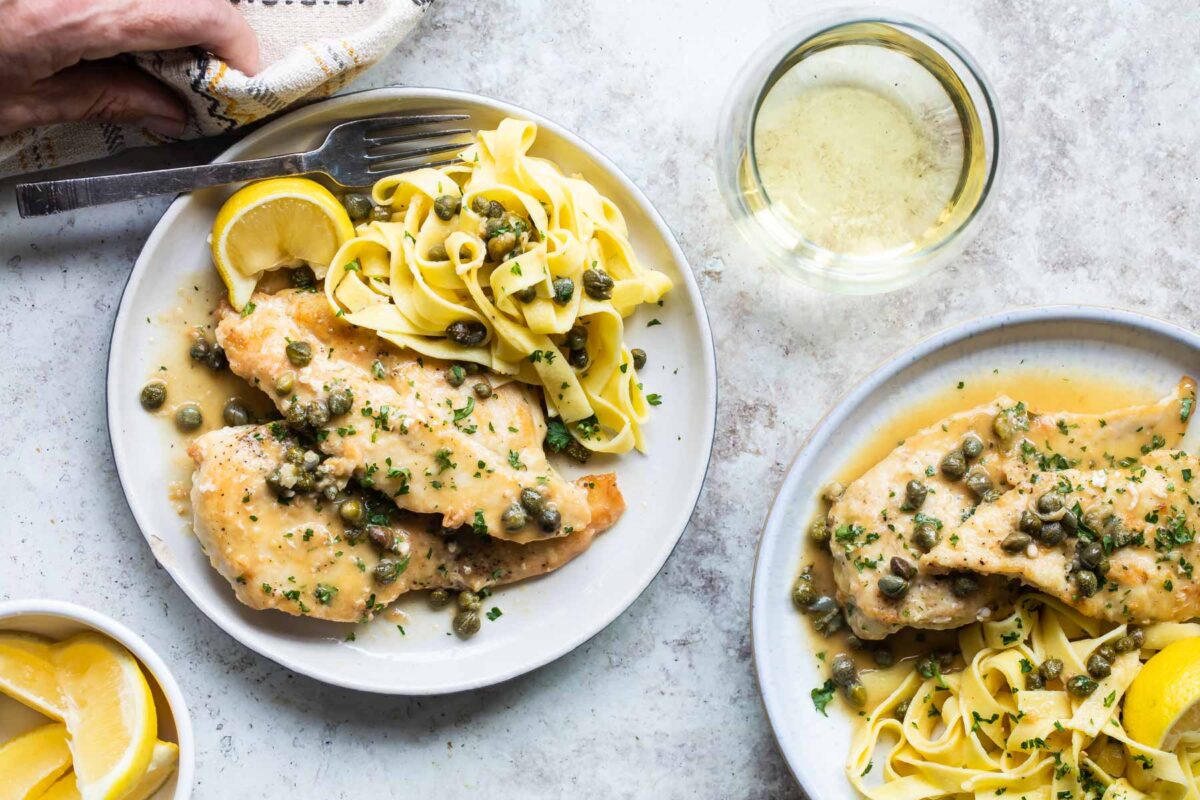 Two plates of chicken scallopini.