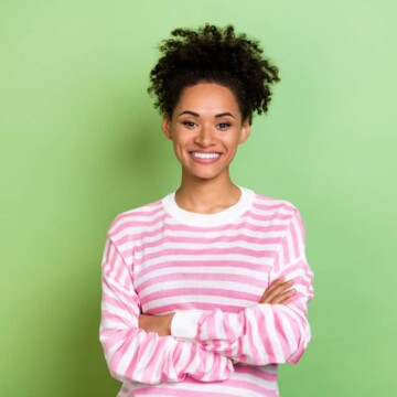 Cute African American female with color-treated hair follicles on 3C healthy hair after a salon treatment.