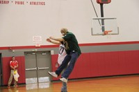 teachers jump in air bumping hips greeting each other at pep rally