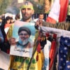 Iranian people in the streets protesting against the United States holding pictures of a slain Hezbollah leader and a burning American flag