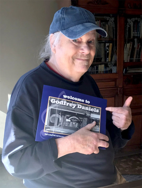 Dave shows off his book 'Welcome to Godfrey Daniels: How a Small Folk Club Became a Legendary Venue for Musicians from Around The World.'