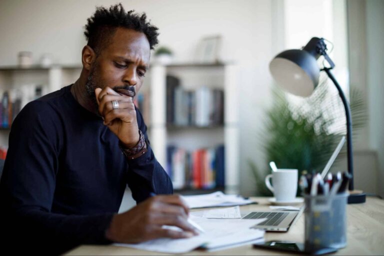 worried man going over bills thinking about bankruptcy