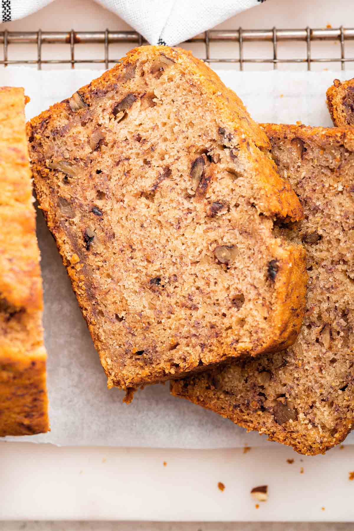 Macro shots of slices of eggless banana bread with pecans.