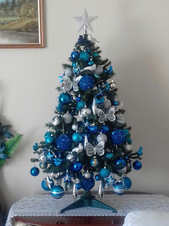 a lovely tabletop Christmas tree with silver, bold blue and navy ornaments and butterflies is an amazingly chic and bold idea