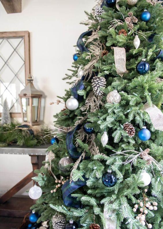 beautiful and natural Christmas tree decor with pinecones, silver, blue and navy ornaments and ribbons is very chic