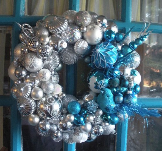 a pretty silver, white and blue Christmas wreath with feathers, beads and branches is a lovely decoration to rock