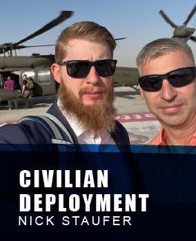 Two men wearing sunglasses taking a selfie in front of military helicopters, with one man sporting a beard and a backpack, and the other in a pink shirt. The helicopters’ rotors are in motion in the background. The banner below states 'Civilian deployment Nick Staufer'