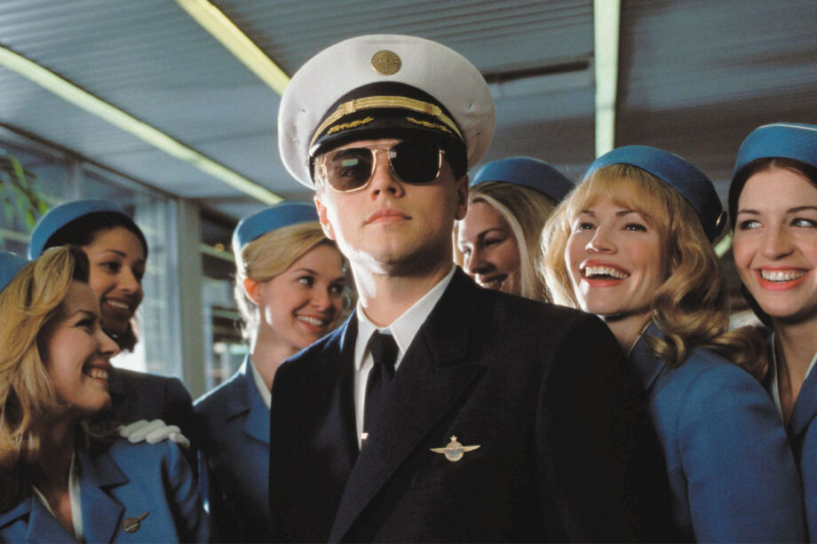 Pilot in uniform with flight attendants at airport.