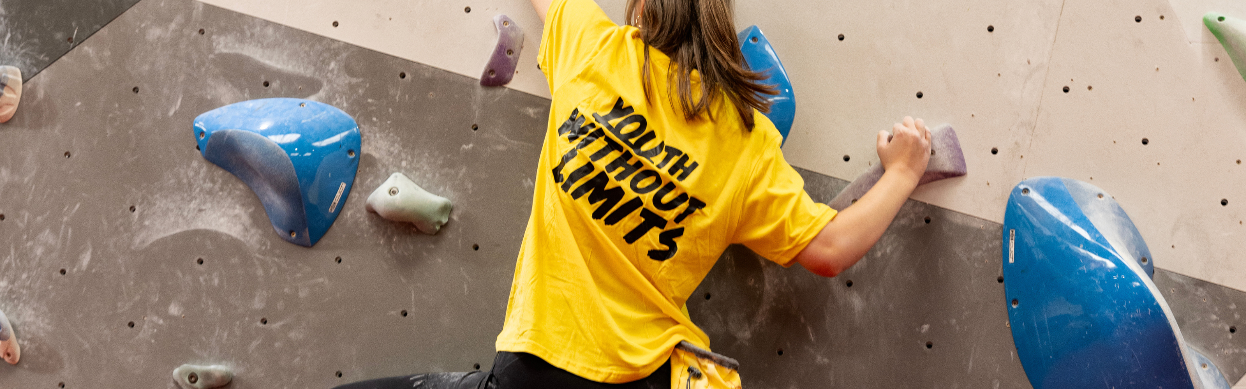 A person wearing a yellow t-shirt with the words 