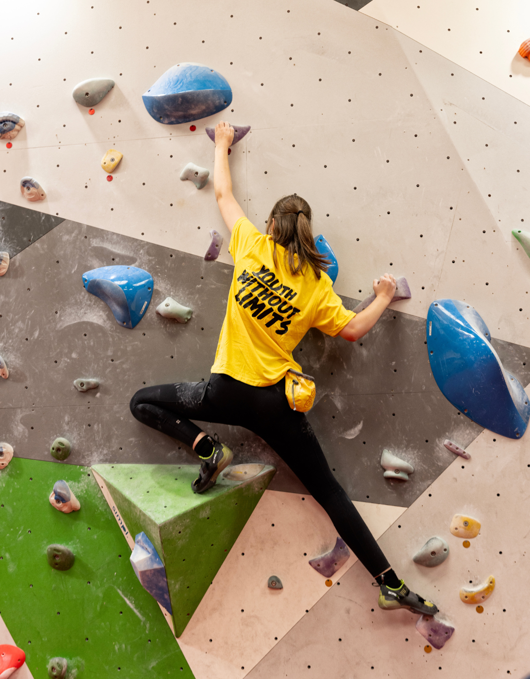 A person wearing a yellow t-shirt with the words 