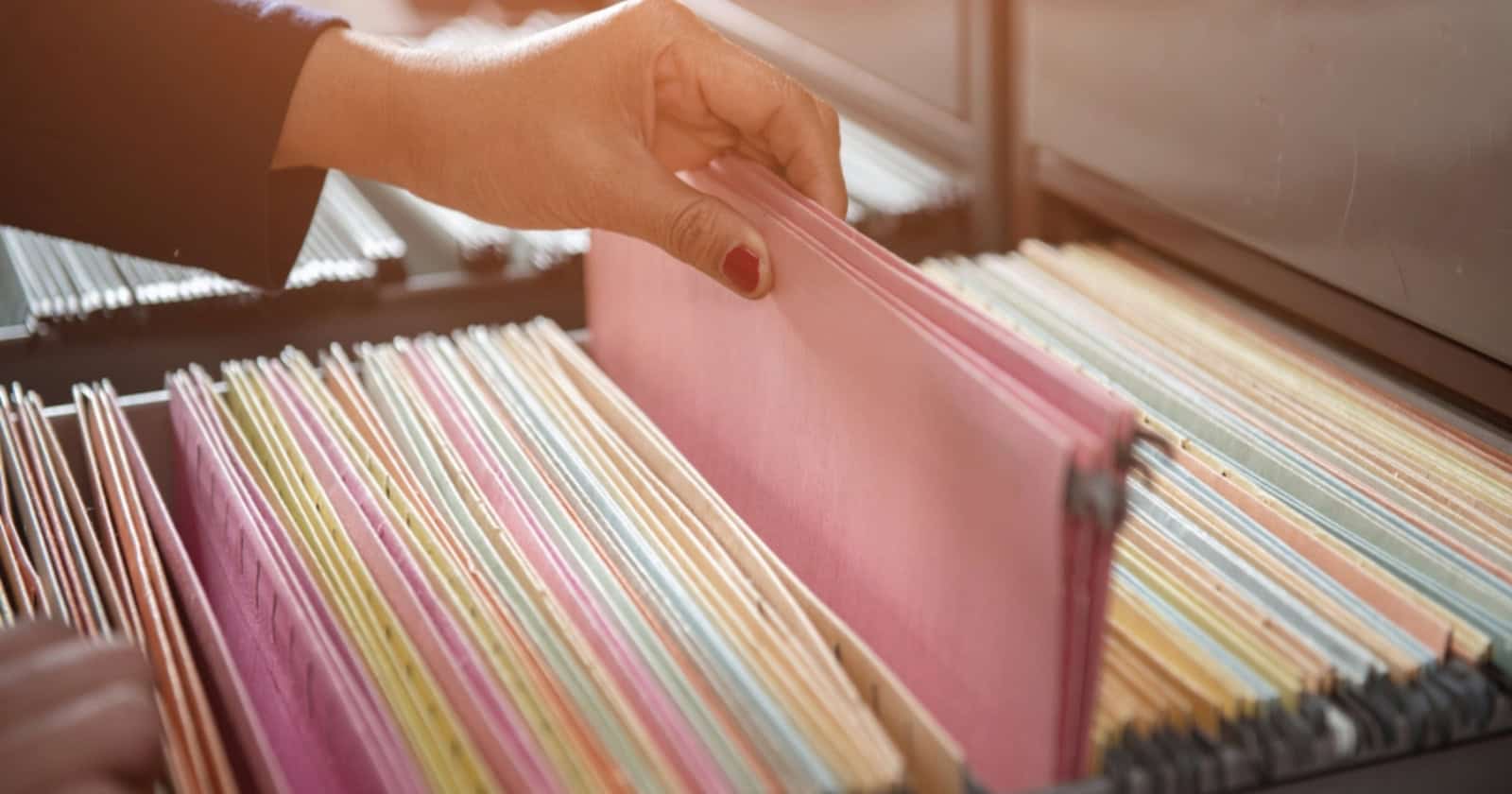 hand grabbing RV document folder from filing cabinet