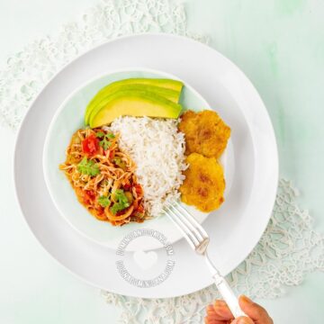 Stewed cabbage served with rice, avocado and tostones.