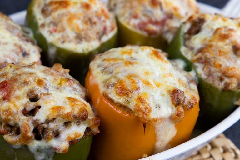 Stuffed bell peppers in a white baking dish.