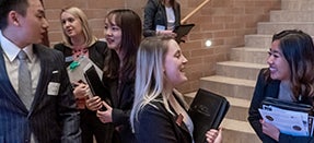 Individuals talking in a hallway