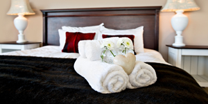 inside of a hotel room with towels arranged on the bed