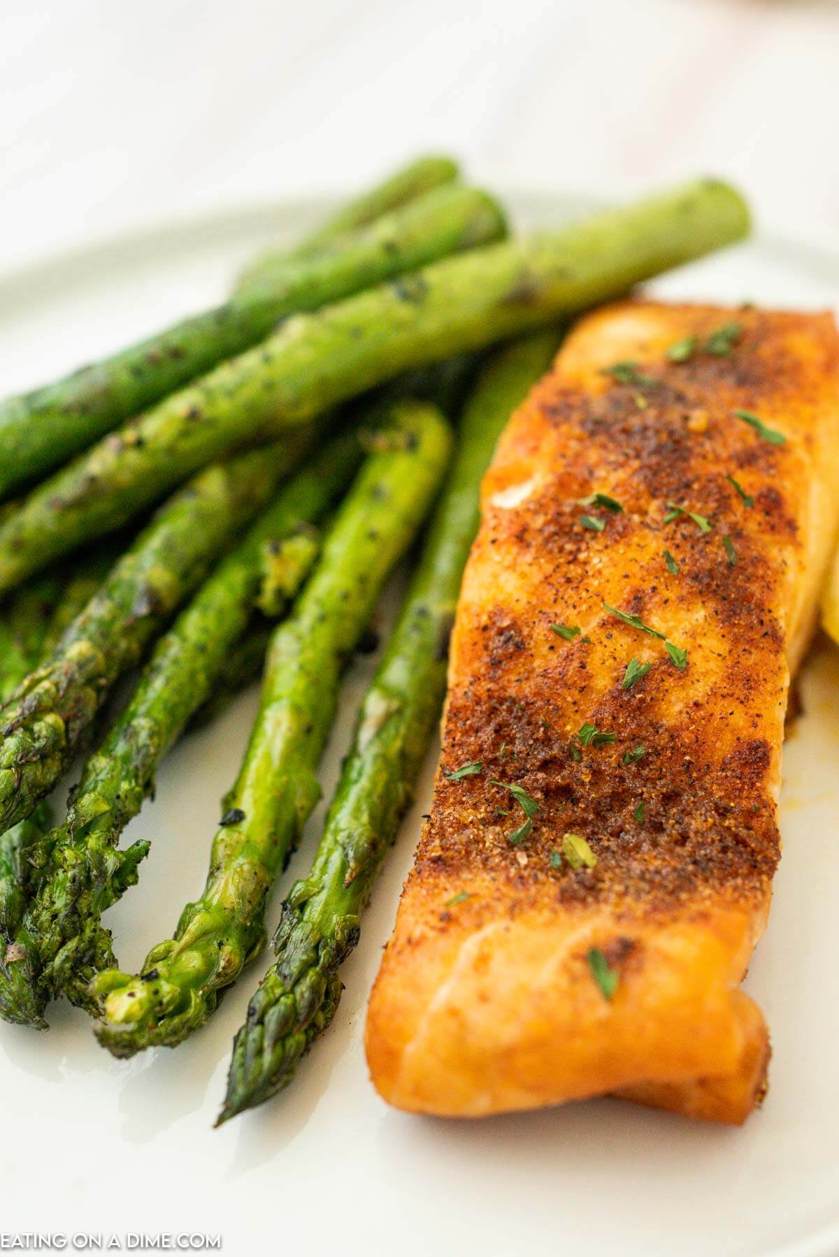 Air fryer Salmon on a plate with asparagus and fresh lemon