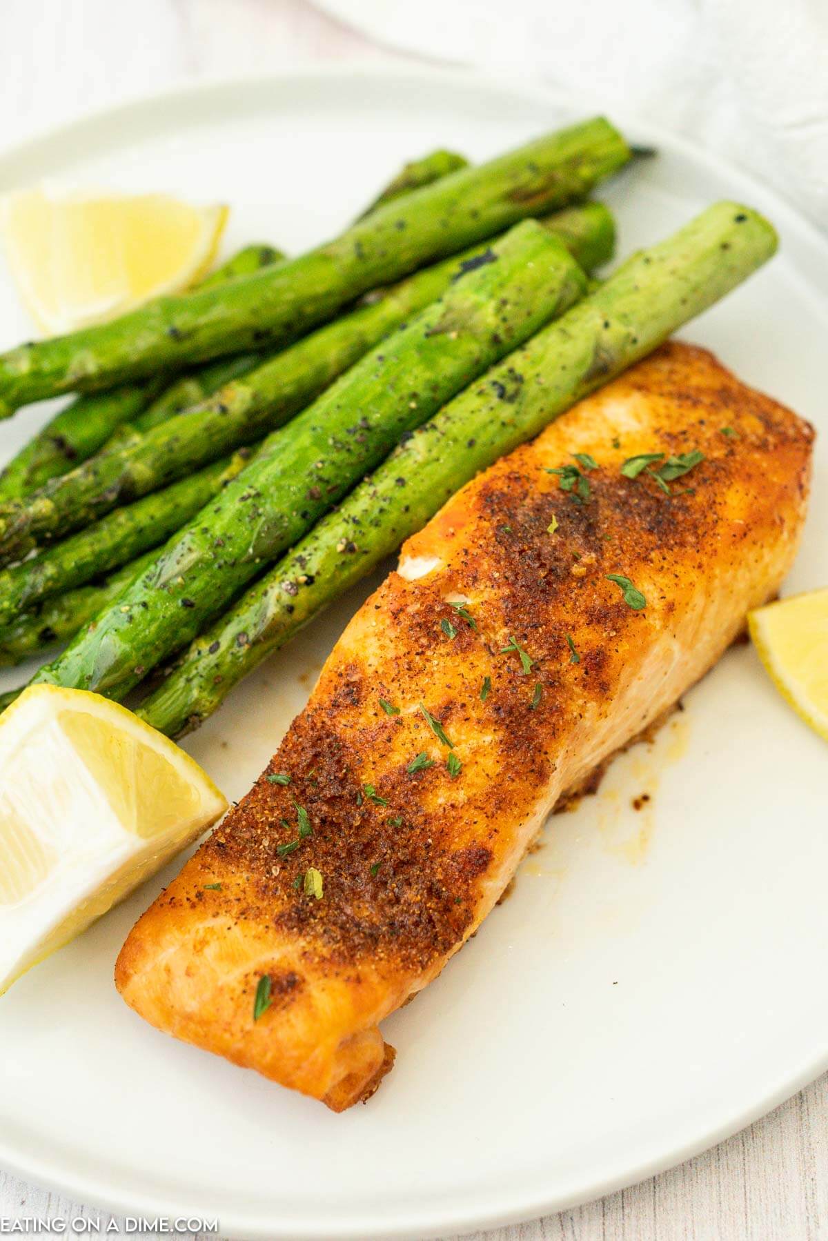 Air fryer Salmon on a plate with asparagus and fresh lemon