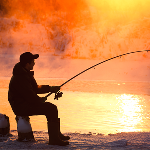 Silhouette of a man fishing at sunset