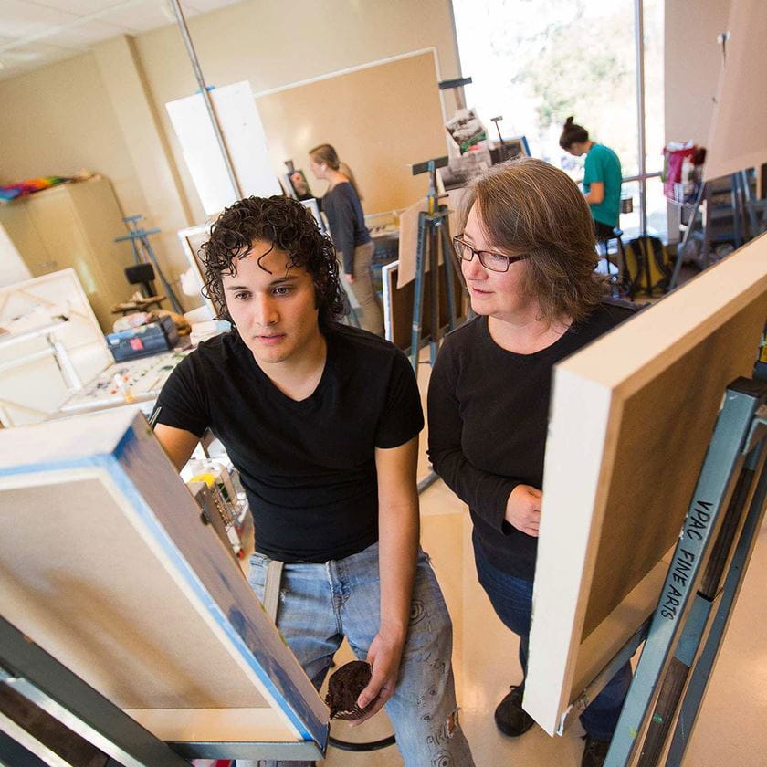 a student demonstrating a painting to the instructor