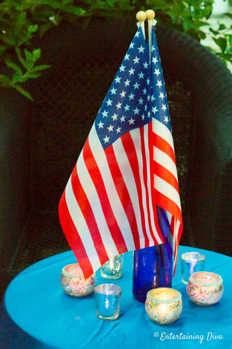 Blue wine bottles as a flag stand to create a patriotic centerpiece