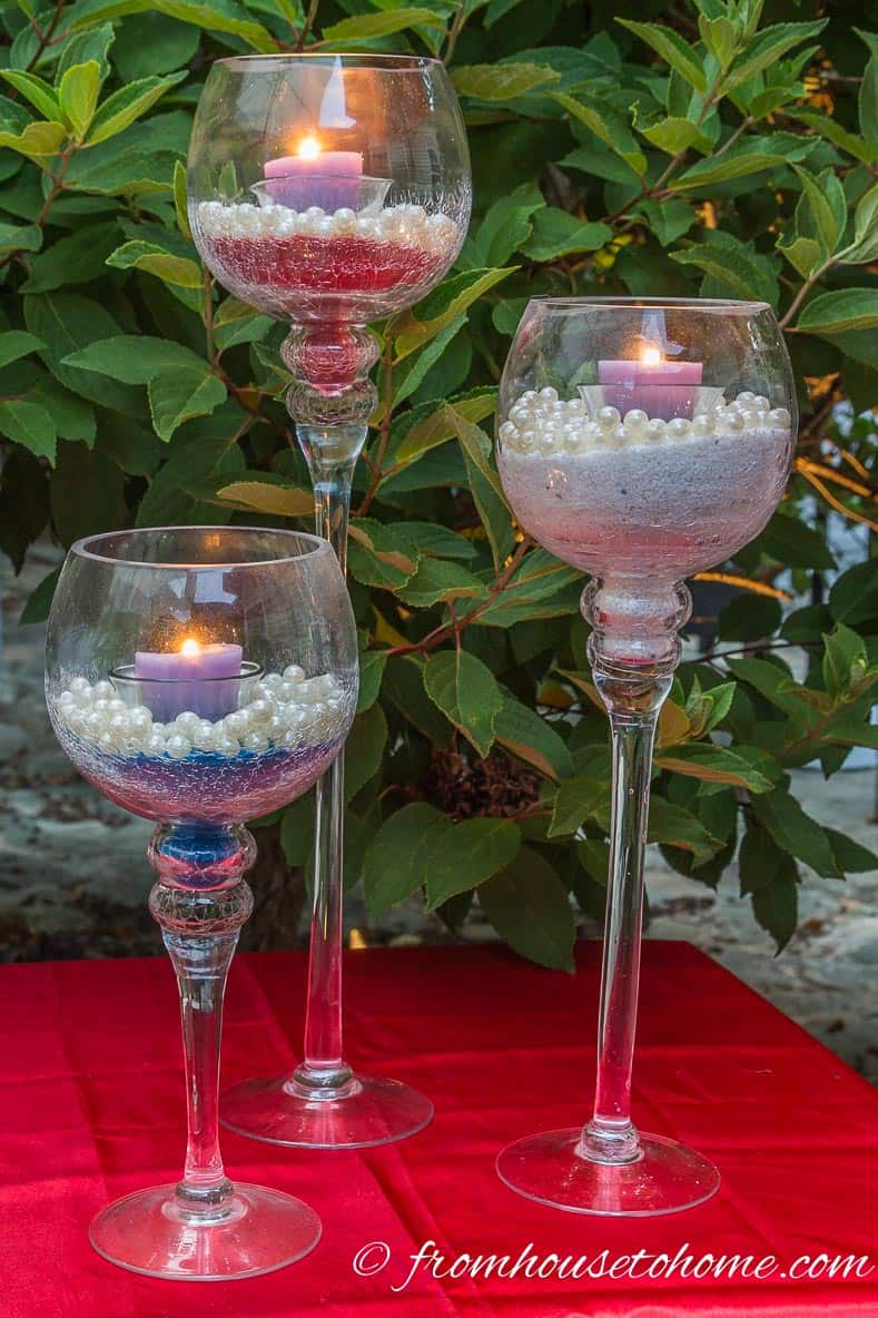 Red, white and blue sand candle holders on a red tablecloth