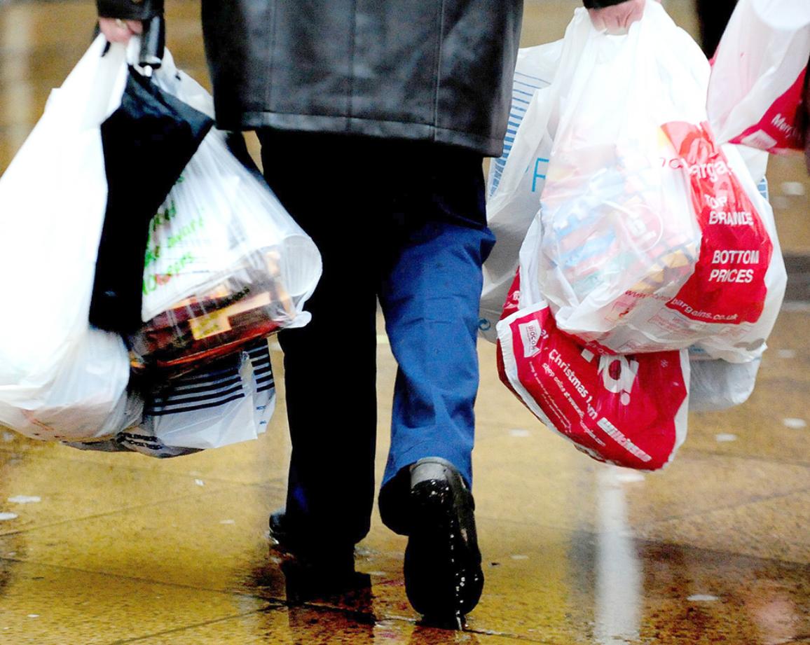 A shopper with carrier bags as ministers have made a "complete mess" of moves to introduce a 5p charge on carrier bags in England