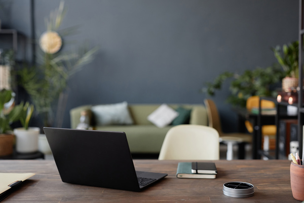 A Laptop Sitting on Top of a Wooden Desk in a Living Room