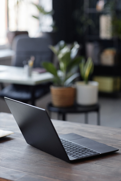 A Laptop Computer Sitting on Top of a Wooden Desk in an Office