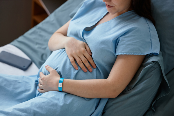 A Pregnant Woman in a Hospital Bed Holding Her Stomach