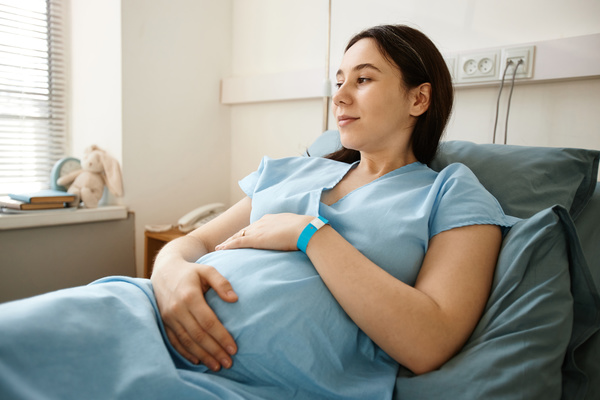 A Pregnant Woman Laying on a Bed in a Hospital Room