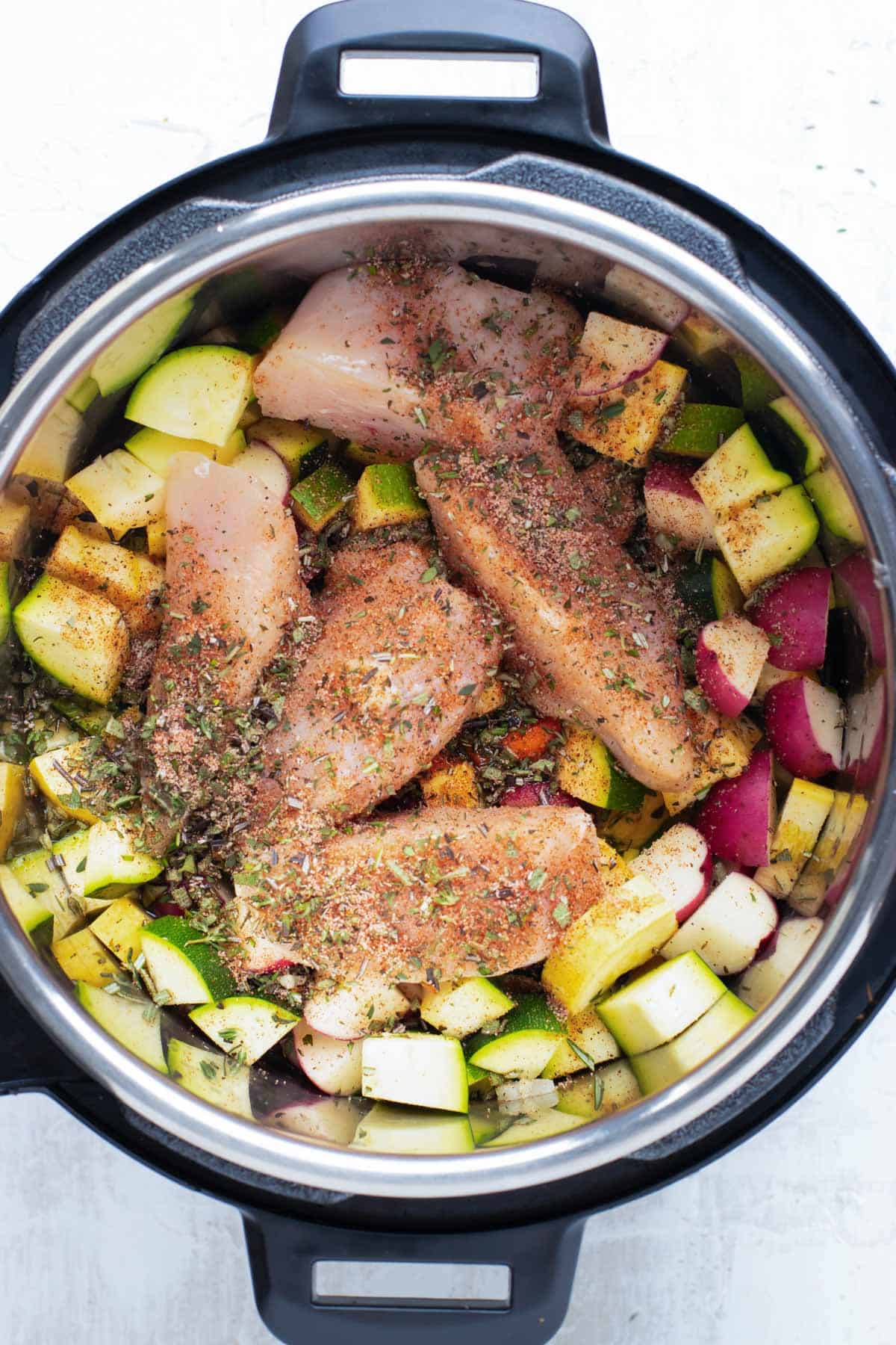 The ingredients for a chicken and vegetable soup in an Instant Pot.