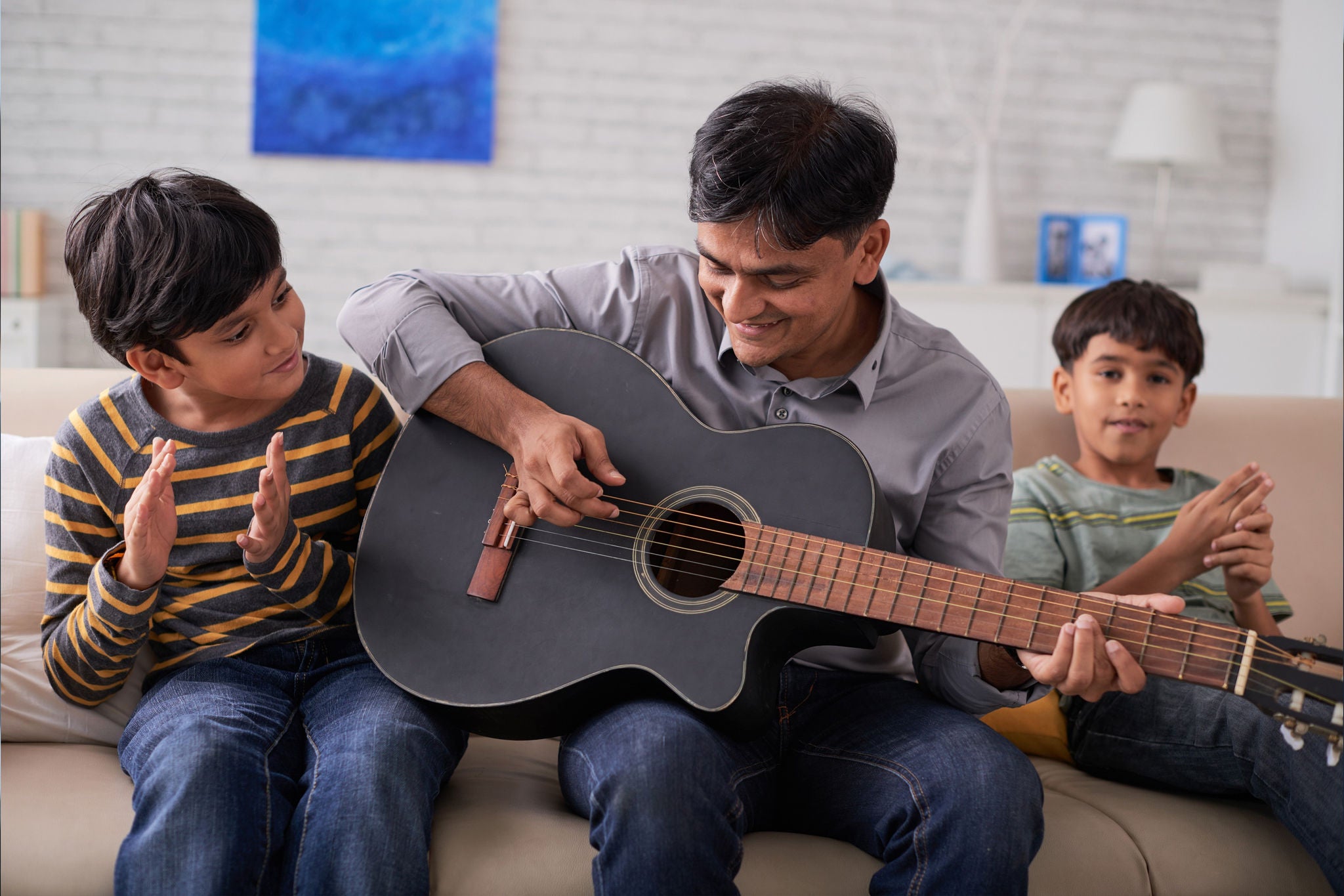 Father playing guitar and his sons singing