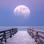 Moon sign meaning represented by a full Moon over a wooden pier above an ocean.