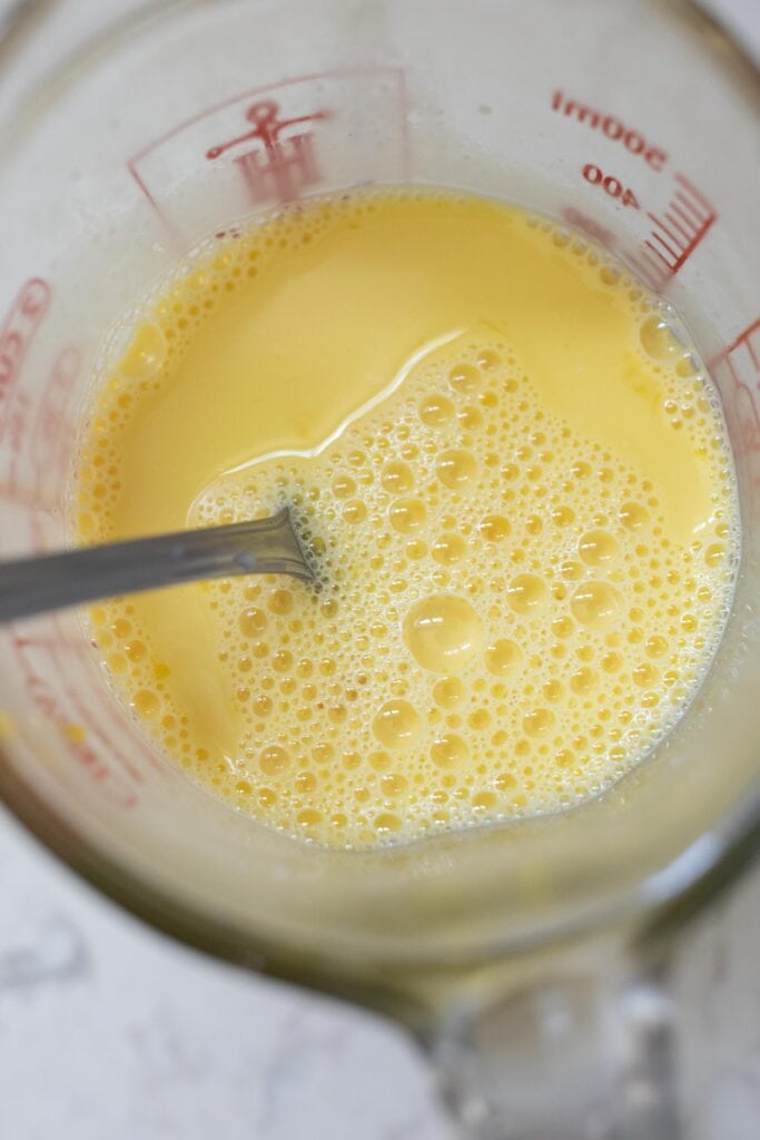 Combining egg yolks in a measuring cup.