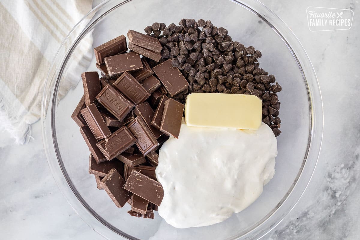 Large glass bowl with chips, broken up Hershey bars, butter and marshmallow creme for See's Fudge.