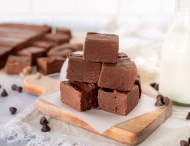 Stacked pile of See's Fudge on a cutting board with milk.