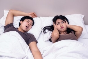 man snoring and girlfriend annoyed