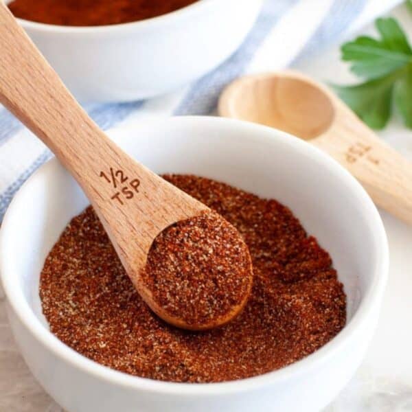 Bowl of chili seasoning and wooden teaspoon.