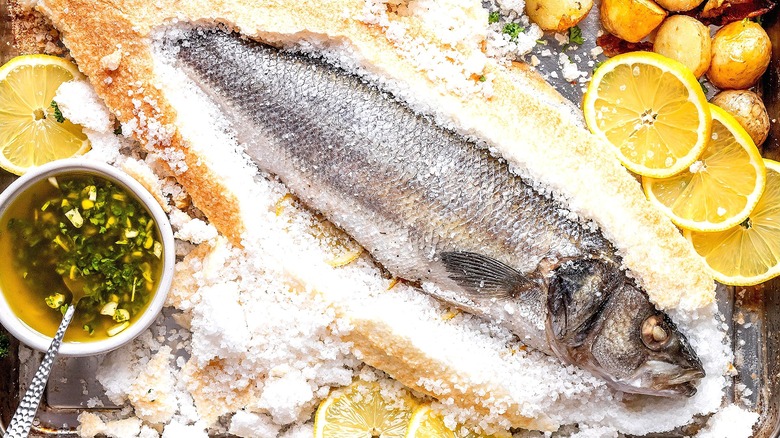 Salt-baked fish with fresh sliced lemons and roasted potatoes