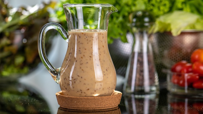 Homemade salad dressing in a glass jar with pour spout